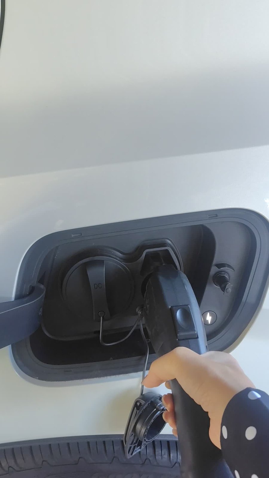車の充電口にコネクタを差し込んでいるところ